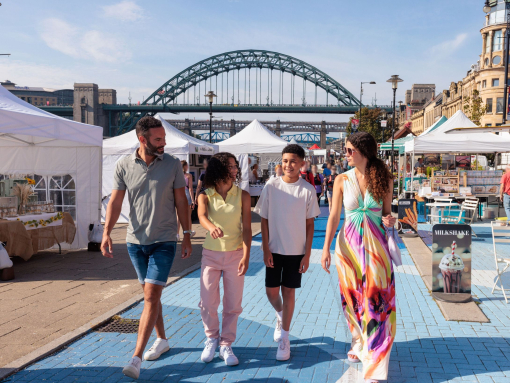 A family visit a Sunday market by the river Tyne in Newcastle upon Tyne