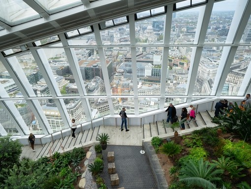 People walking down the stairs Sky Garden wth the city in the background