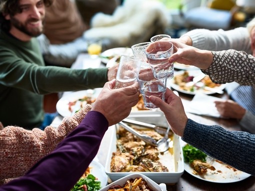 A group of people or relatives tasting drinks at a lunch.