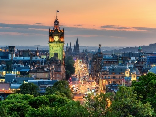 Balmoral's clock tower with Edinburgh cityscape skyline and Scott Monument background during sunset