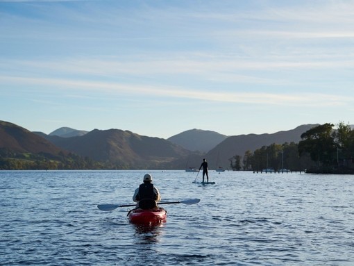 Kayaker and stand up paddle boarder on a lake