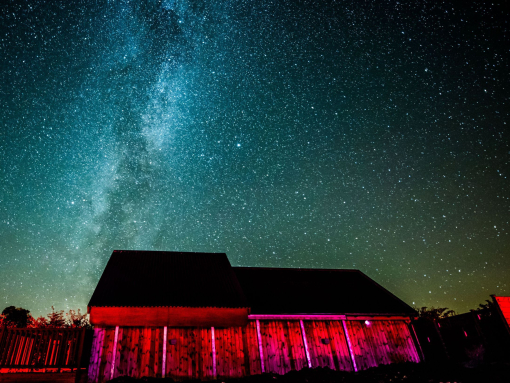 A dark sky observatory lit up at night under the sky.