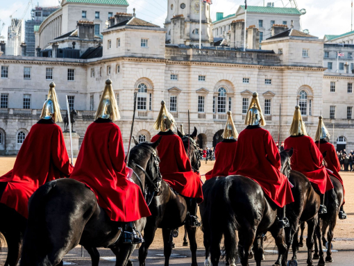 Horse Guards wearing red coats riding across parade