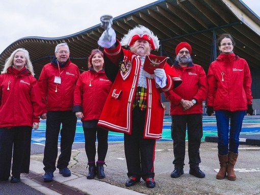 A group of people pose with a Town Crier