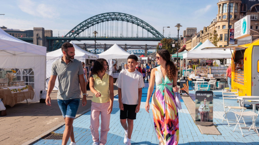 A family visit a Sunday market by the river Tyne in Newcastle upon Tyne