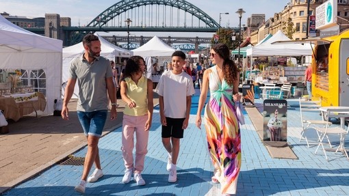 A family visit a Sunday market by the river Tyne in Newcastle upon Tyne