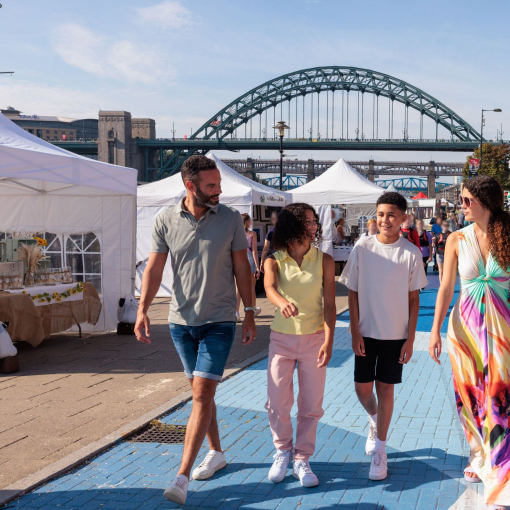 A family visit a Sunday market by the river Tyne in Newcastle upon Tyne