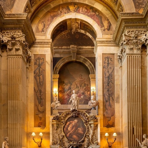 Interior shot of ornate fireplace and arch with painted ceiling and frescoes