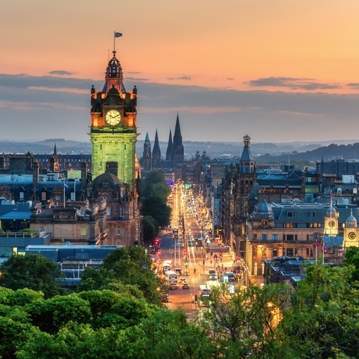 Balmoral's clock tower with Edinburgh cityscape skyline and Scott Monument background during sunset