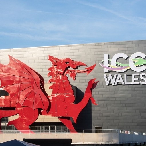 Convention Centre exterior in daylight, featuring a red Welsh dragon and a sign reading: ICC Wales.