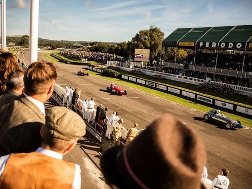 Spectators watching a motor race of vintage sports cars