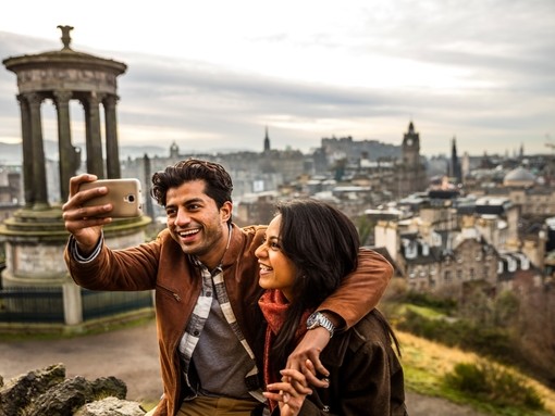 A young couple taking a selfie of view over historic town