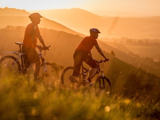 Two men on mountain bikes cycling at Devil's Dyke. Sunrise