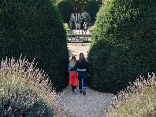 Male and female couple hugging in the garden near a fountain