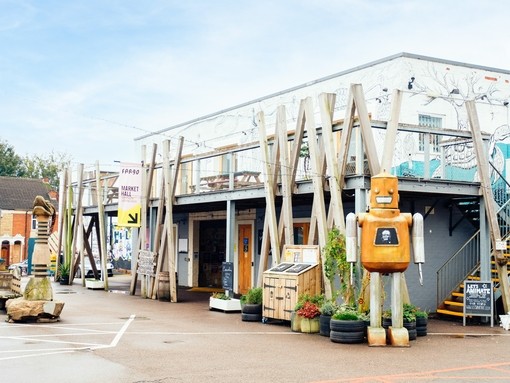 Robot sculpture outside a building with geometric décor