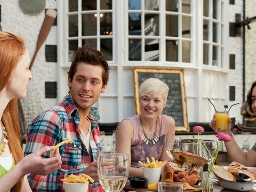 A group of people in a restaurant in Brighton, eating in the open air at Fishy Fishy restaurant.