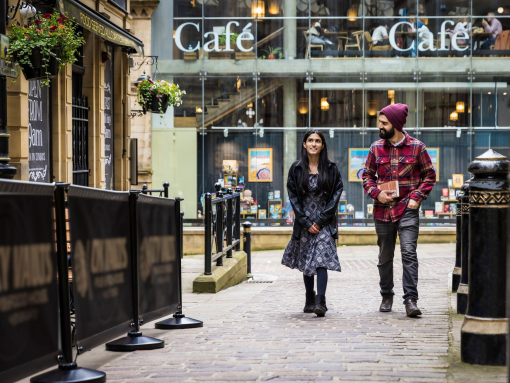 A woman and a man walk through a town centre