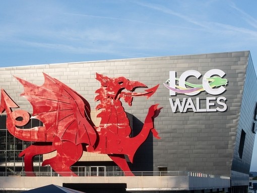 Convention Centre exterior in daylight, featuring a red Welsh dragon and a sign reading: ICC Wales.