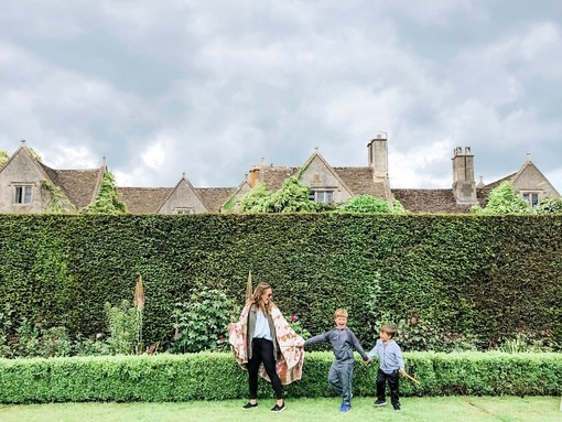 Mother and sons standing in garden in front of a tall hedge