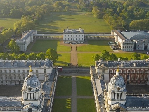 Aerial view of a massive mansion and manicured gardens.