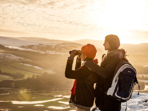 Woman and teenager in a wintery landscape looking at the view