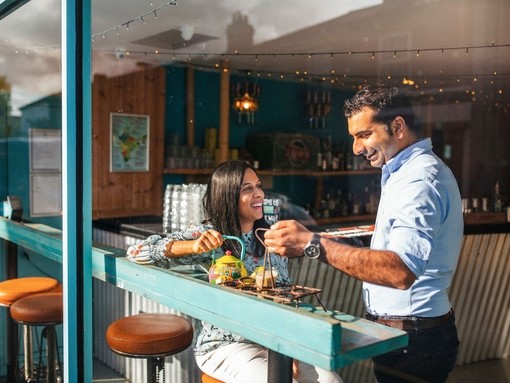 Man and a woman enjoying food at window table in a cafe.