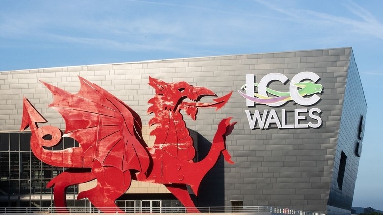Convention Centre exterior in daylight, featuring a red Welsh dragon and a sign reading: ICC Wales.