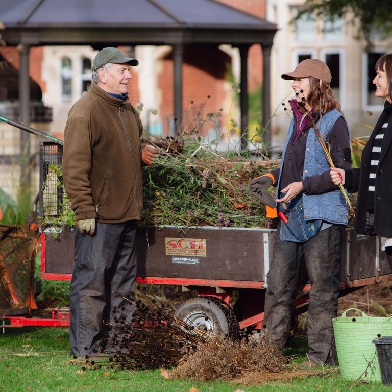 Three people gardening in a garden