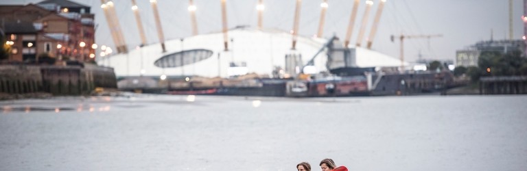 Two girls kayaking on the river in front of the O2 arena